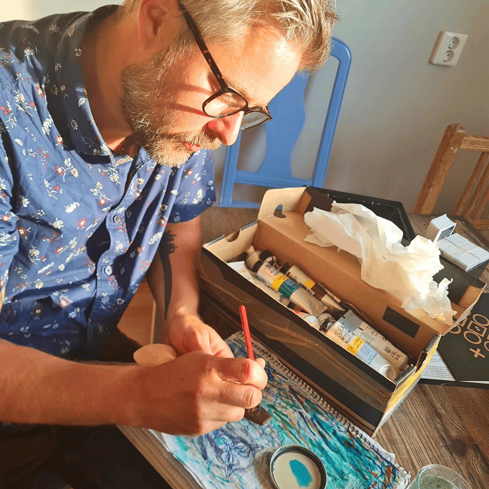 Sebastian Ungh creating detailed artwork with brushes and paints.