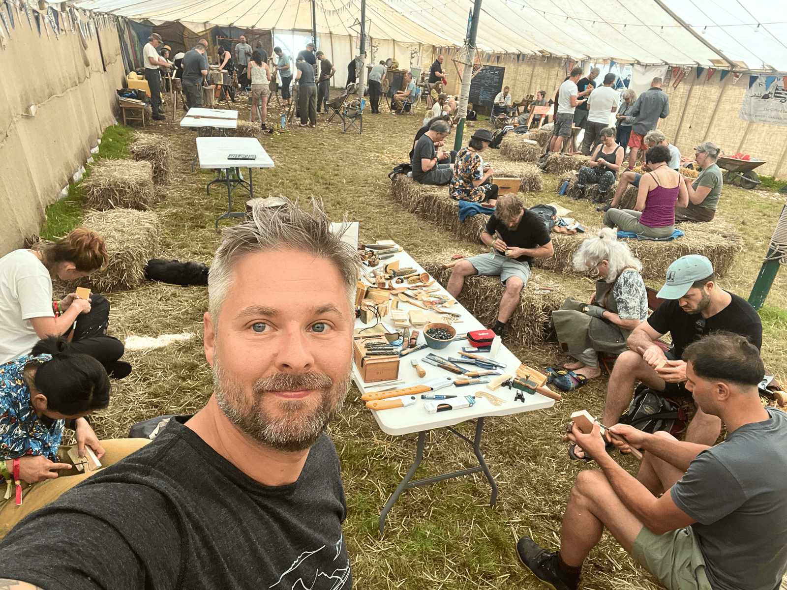 Handcrafted woodworking at Sebastian Ungh event Man taking selfie at woodworking workshop event.